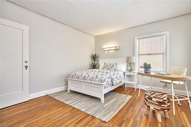 bedroom with baseboards and light wood finished floors