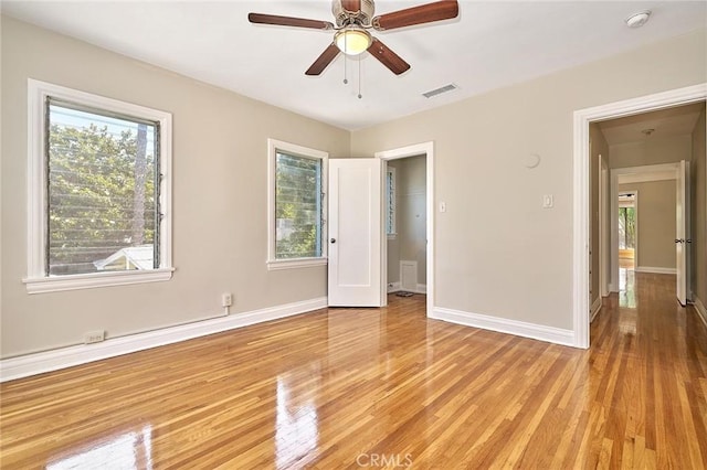unfurnished room with light wood-style flooring, baseboards, and visible vents