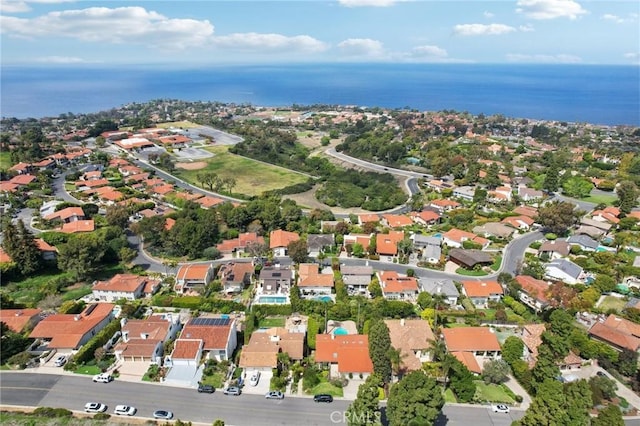 aerial view of property and surrounding area featuring a large body of water and nearby suburban area
