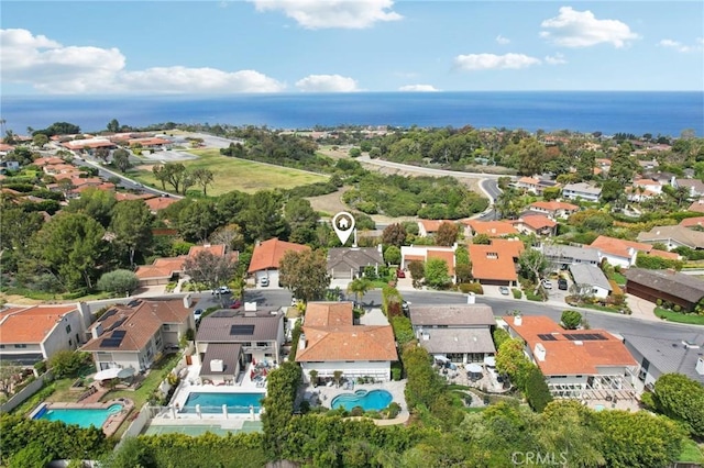 aerial view of property's location with a pool area, nearby suburban area, and a nearby body of water