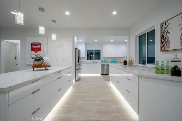 1657 S Sunrise Way, Palm Springs, CA 92264 - kitchen with white cabinetry, modern cabinets, light wood-style flooring, stainless steel appliances, and decorative light fixtures