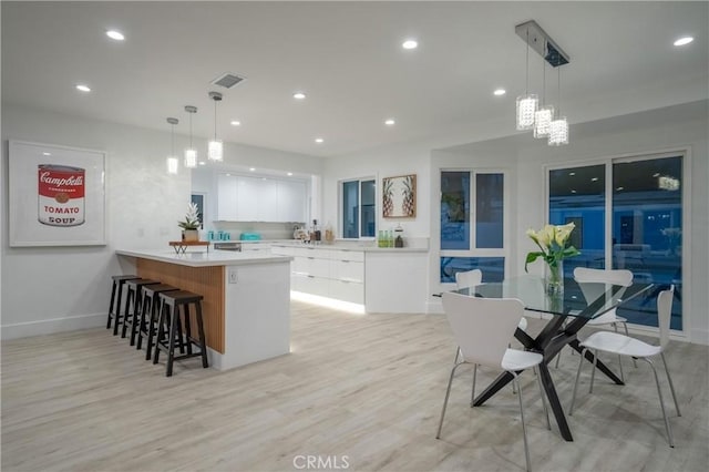 1657 S Sunrise Way, Palm Springs, CA 92264 - kitchen with a breakfast bar, visible vents, white cabinets, a peninsula, and modern cabinets