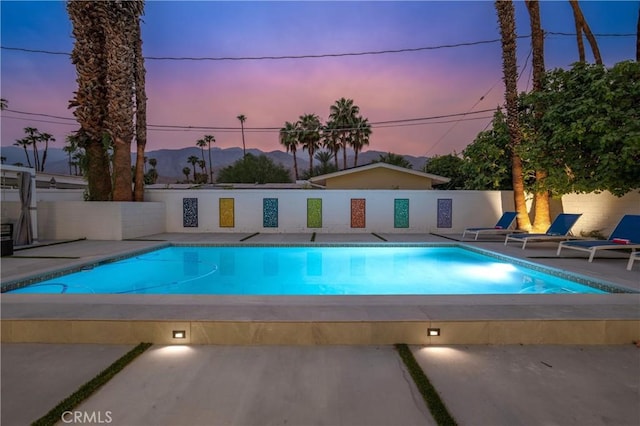 1657 S Sunrise Way, Palm Springs, CA 92264 - pool at dusk with a fenced in pool, fence, and a patio