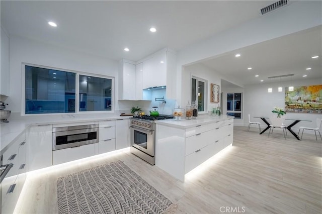 1657 S Sunrise Way, Palm Springs, CA 92264 - kitchen featuring high end range, white cabinets, visible vents, modern cabinets, and recessed lighting