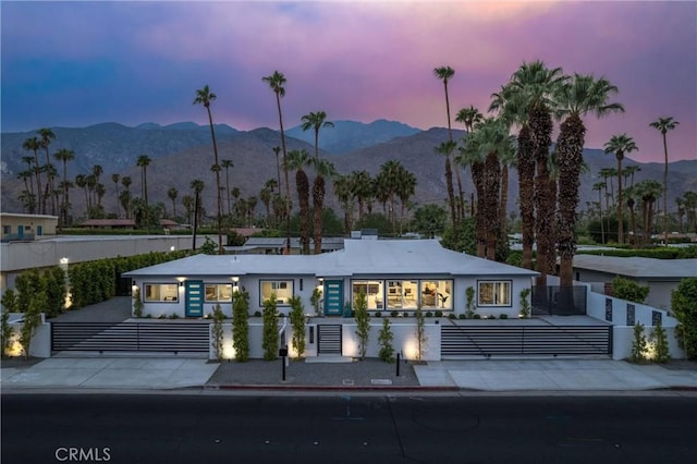1657 S Sunrise Way, Palm Springs, CA 92264 - view of front of house featuring stucco siding, a fenced front yard, and a mountain view
