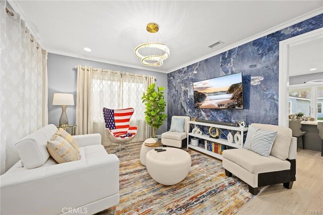 living area with crown molding, wood finished floors, wallpapered walls, an inviting chandelier, and visible vents