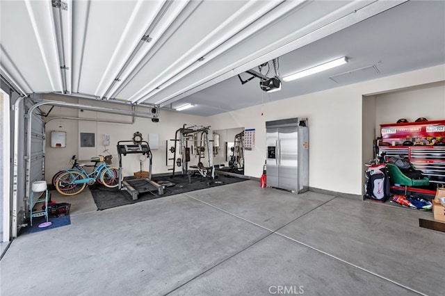 5053 Moon Eye Way, Hemet, CA 92545 - garage with stainless steel fridge, electric panel, and a garage door opener