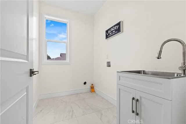 laundry area with hookup for a washing machine, baseboards, marble finish floor, a sink, and cabinet space