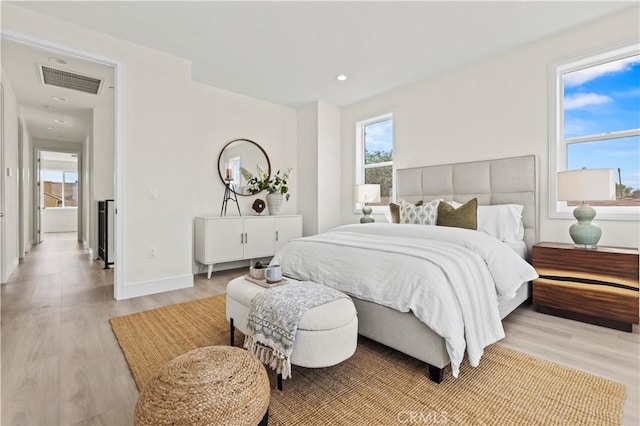 bedroom featuring light wood finished floors, baseboards, visible vents, and recessed lighting