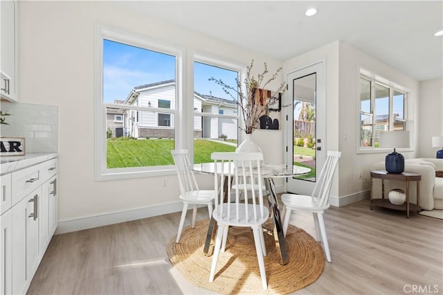 dining space featuring baseboards, light wood-style floors, and recessed lighting