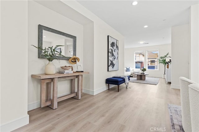 hall with light wood finished floors, baseboards, and recessed lighting