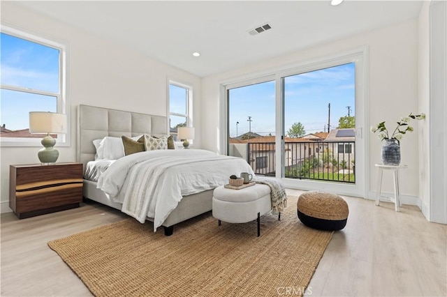 bedroom featuring baseboards, access to outside, light wood finished floors, and visible vents