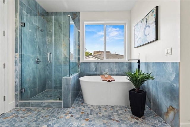 bathroom with a freestanding tub and a shower stall