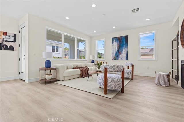 living area with baseboards, recessed lighting, and light wood finished floors