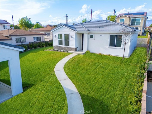 rear view of house with a tile roof and a yard