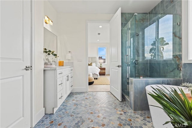 full bath featuring baseboards, connected bathroom, a stall shower, and vanity