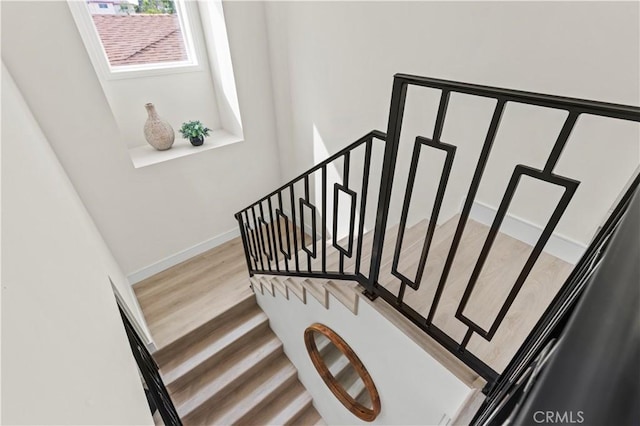 stairs with baseboards and wood finished floors