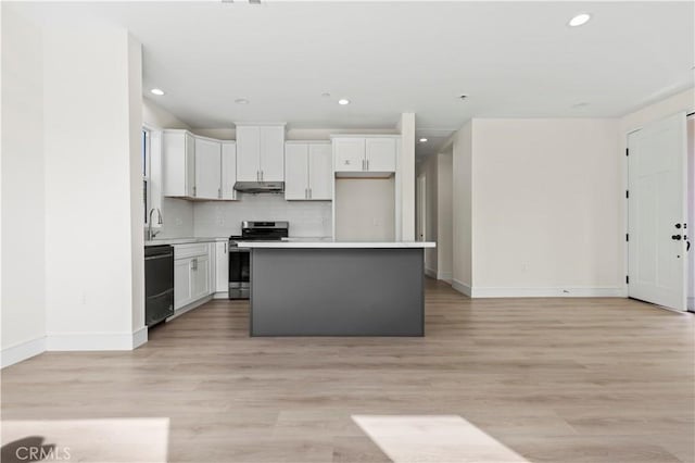 kitchen featuring stainless steel range, dishwasher, a center island, under cabinet range hood, and decorative backsplash