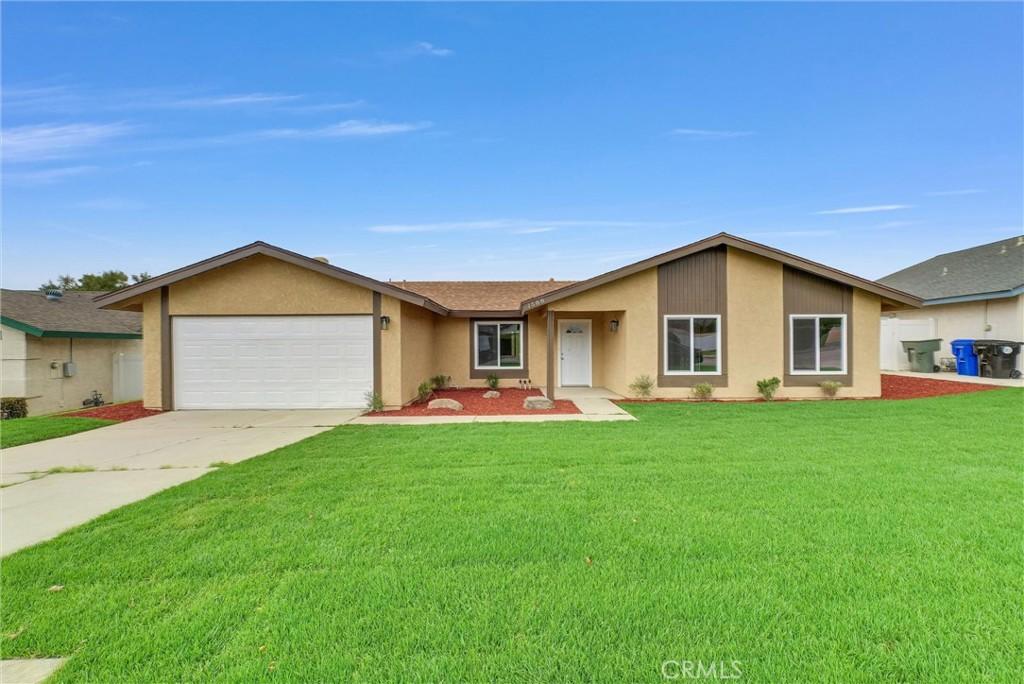 1588 Buckeye St, Highland, CA 92346 - view of front facade featuring stucco siding, a garage, a front lawn, and concrete driveway