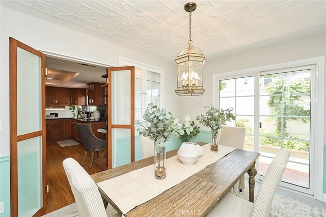 385 Park Ave, Long Beach, CA 90814 - dining room with visible vents, wood finished floors, and a notable chandelier