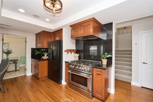 385 Park Ave, Long Beach, CA 90814 - kitchen with visible vents, high end range, wood finished floors, and black fridge