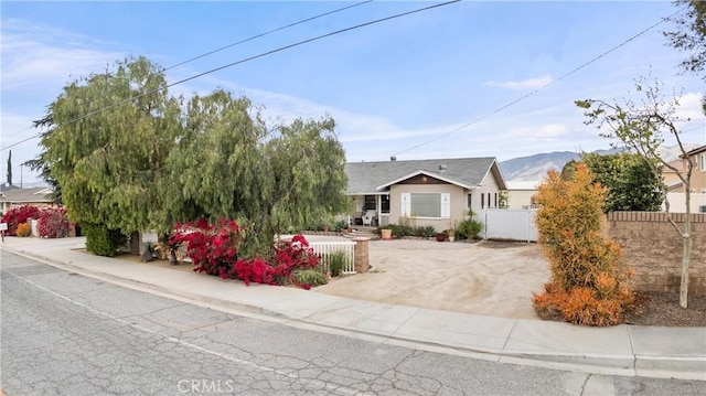 681 E Washington Ave, San Jacinto, CA 92583 - view of front of home featuring fence, stucco siding, and a mountain view