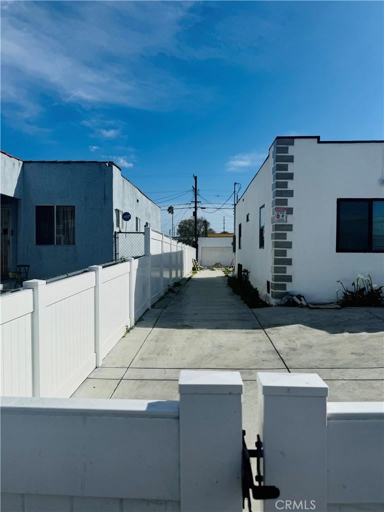 view of side of home featuring stucco siding and fence