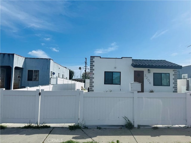 view of front of home featuring a fenced front yard and stucco siding