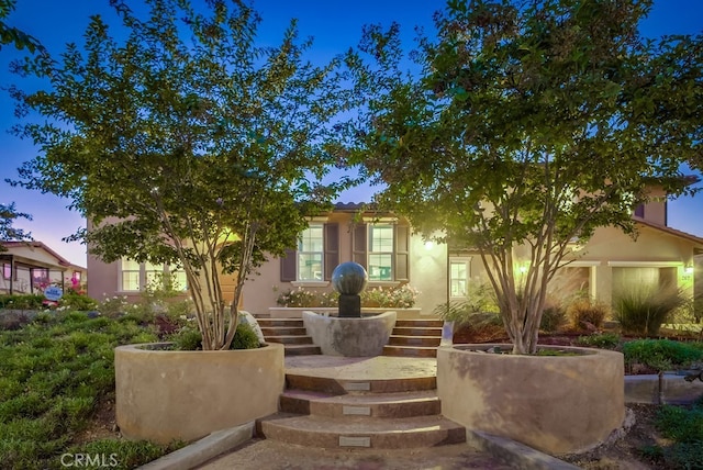 view of front of property with stairway and stucco siding