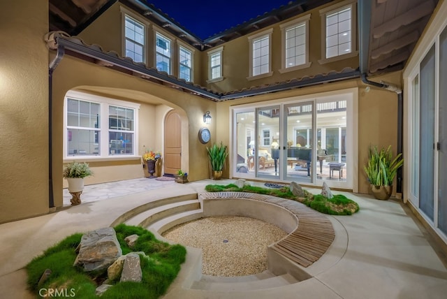back of property with stucco siding and a tiled roof