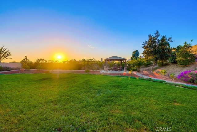 yard at dusk featuring a gazebo