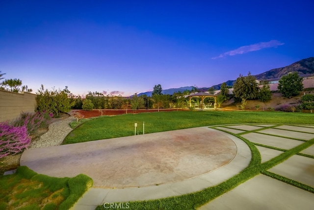 surrounding community featuring a mountain view, a gazebo, fence, a lawn, and a patio