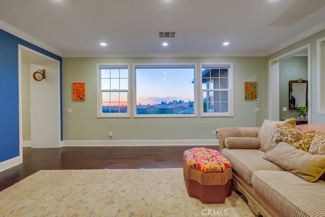 living room with wood finished floors, visible vents, baseboards, and ornamental molding