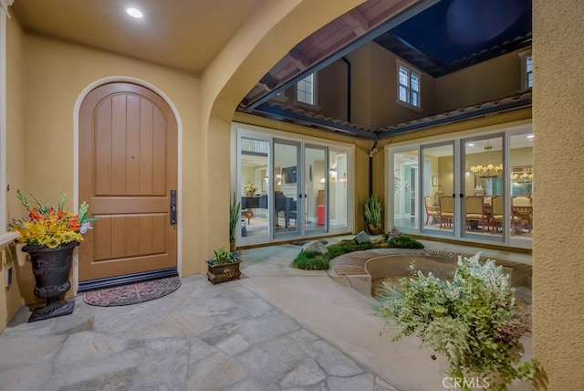 view of exterior entry with stucco siding, a tiled roof, and french doors