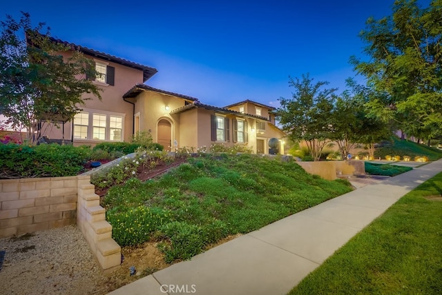 view of front of house featuring a tile roof and stucco siding