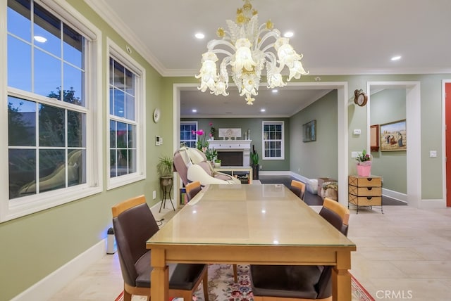 dining room with recessed lighting, crown molding, baseboards, a fireplace, and a notable chandelier
