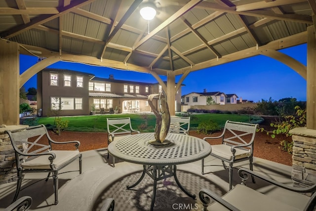 patio at night featuring a gazebo and a yard