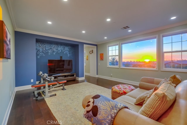 home theater room featuring baseboards, ornamental molding, dark wood-type flooring, visible vents, and recessed lighting