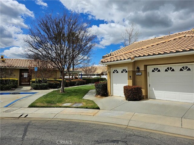 view of front of home featuring concrete driveway, a tile roof, a garage, and stucco siding