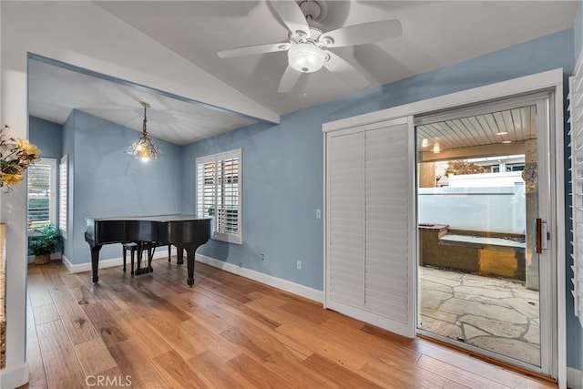 interior space with lofted ceiling, a ceiling fan, wood finished floors, and a healthy amount of sunlight