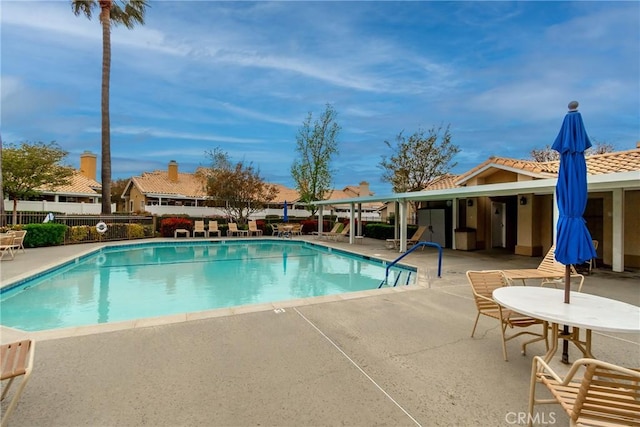 community pool featuring fence and a patio