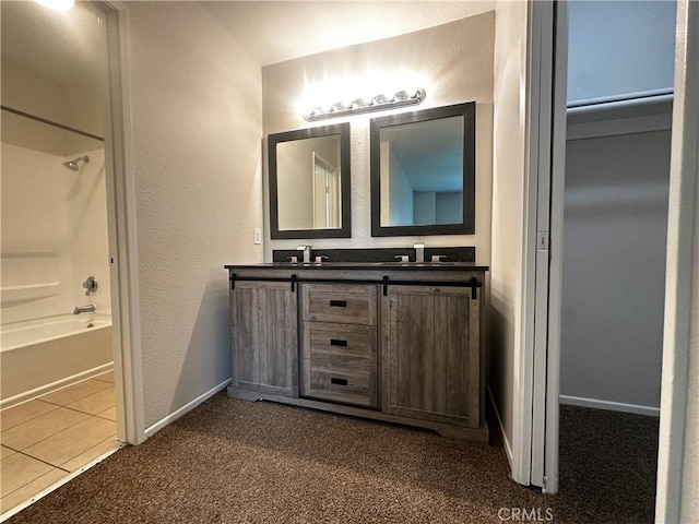 full bathroom with baseboards, washtub / shower combination, a sink, and double vanity