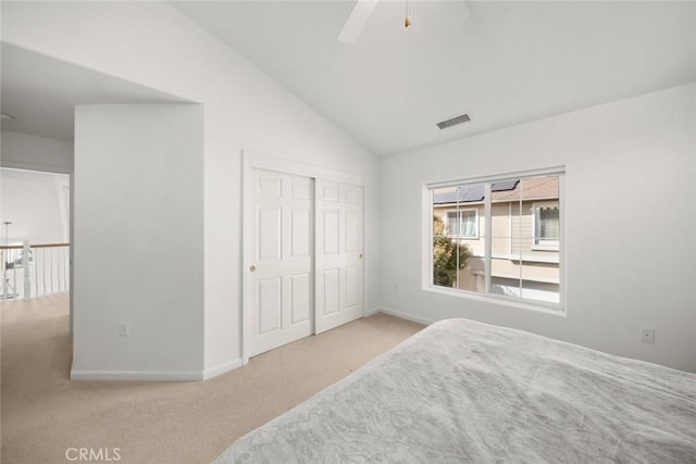 bedroom with vaulted ceiling, a closet, carpet flooring, baseboards, and visible vents