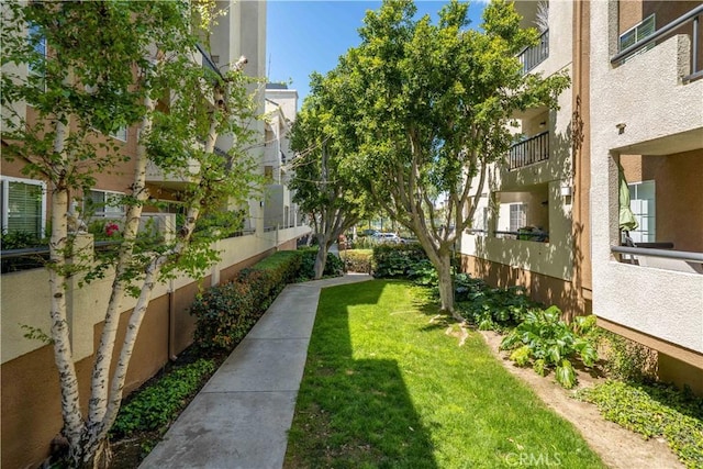 view of property's community with a lawn and fence