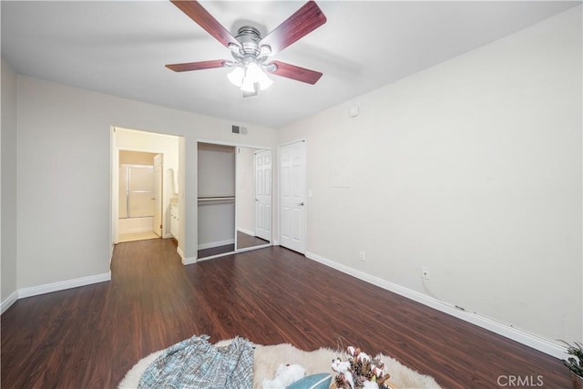 unfurnished bedroom featuring visible vents, baseboards, ceiling fan, connected bathroom, and wood finished floors