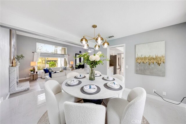 dining space featuring a notable chandelier, baseboards, and visible vents