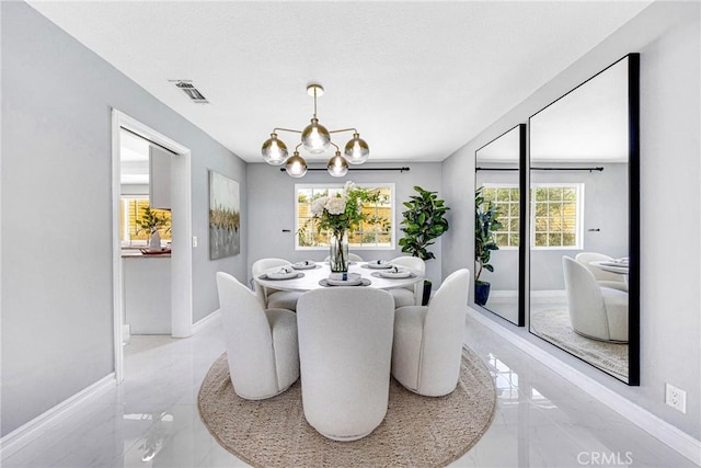 dining room featuring marble finish floor, baseboards, visible vents, and an inviting chandelier