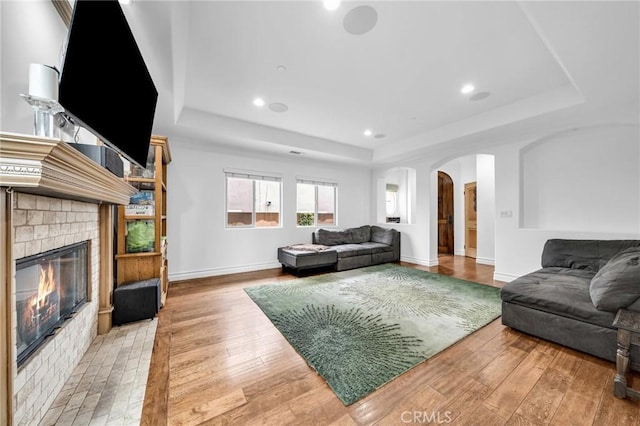 1907 Ernest Ave Unit B, Redondo Beach, CA 90278 - living area featuring a tray ceiling, arched walkways, light wood finished floors, a glass covered fireplace, and recessed lighting