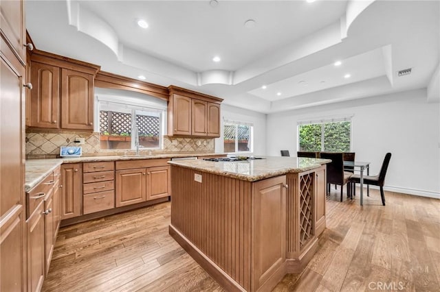 1907 Ernest Ave Unit B, Redondo Beach, CA 90278 - kitchen with light wood-type flooring, a tray ceiling, a center island, backsplash, and recessed lighting