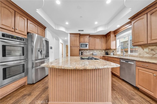 1907 Ernest Ave Unit B, Redondo Beach, CA 90278 - kitchen featuring appliances with stainless steel finishes, a sink, wood finished floors, a center island, and light stone countertops